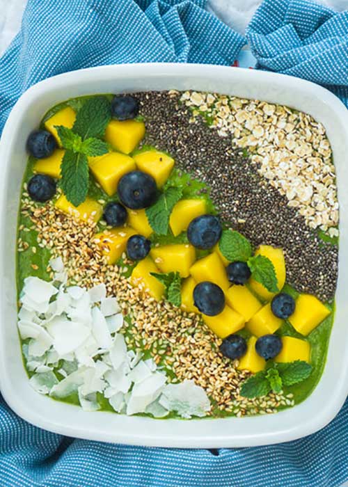 Bild von Grüne Smoothie Bowl mit Mango, Minze, Chia-Samen und süßem Gomasio